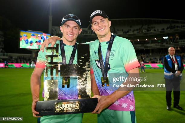 Sam Curran poses for a photograph with Tom Curran and The Hundred Men's Champions Trophy after victory during The Hundred Final between Oval...