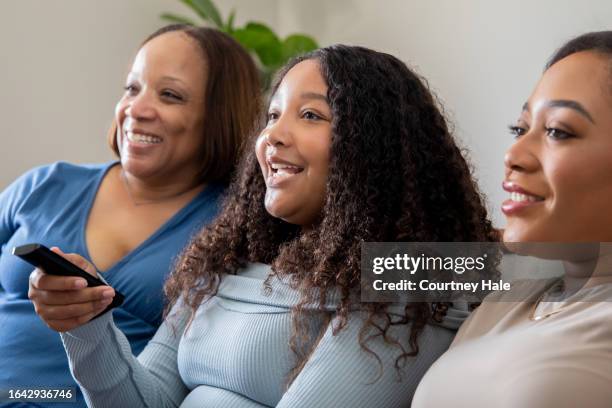 mature mother with her teen and young adult children using technology together at home - black teenage girl stock pictures, royalty-free photos & images