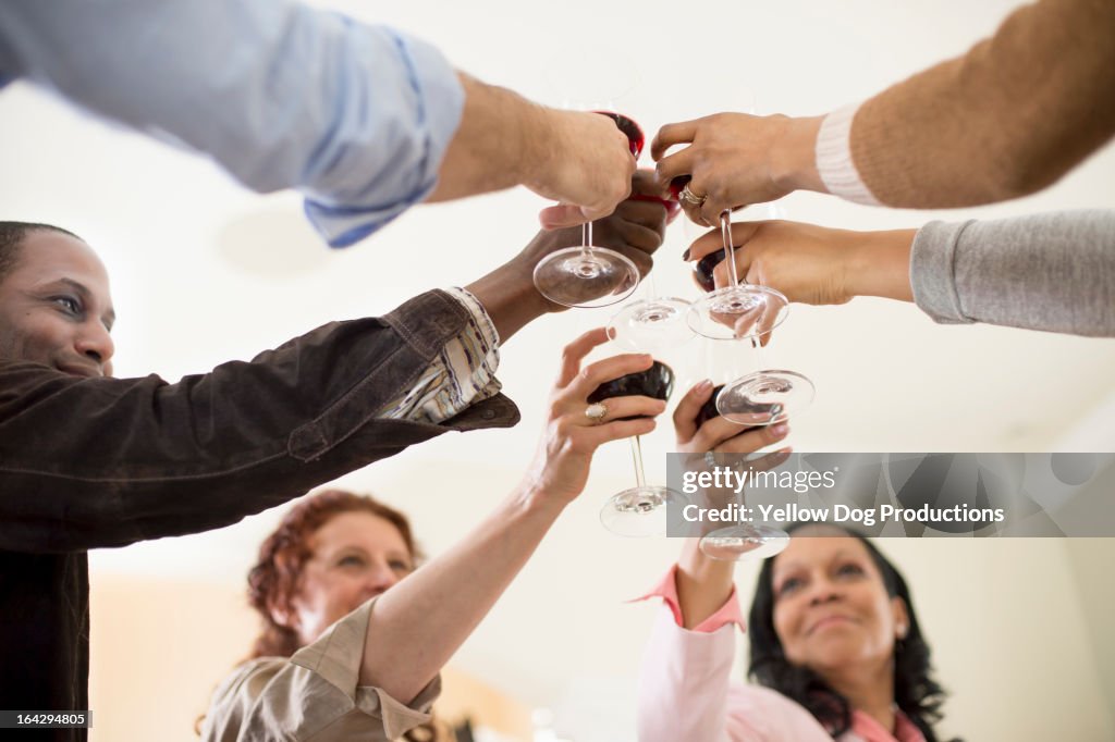 Group of people at party raising wine glasses