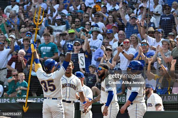 Teoscar Hernandez of the Seattle Mariners celebrates with teammates after hitting a solo home run during the first inning against the Kansas City...