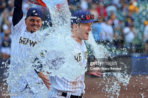 Mark Canha of the Milwaukee Brewers is doused by Willy Adames following a game against the San Diego Padres at American Family Field on August 27,...
