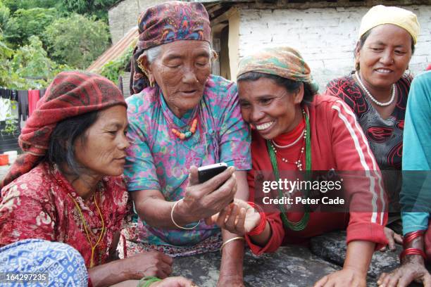 native nepalese women looking at phone - nepal women stock pictures, royalty-free photos & images