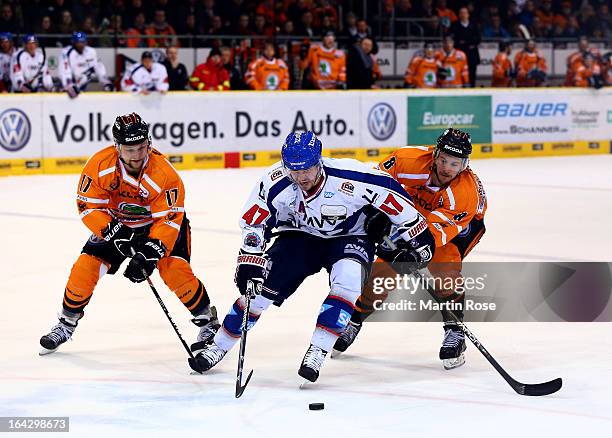 Sebastian Furchner and Kai Hospelt of Wolfsburg and Christoph Ullmann of Mannheim battle for the puck in game two of the DEL play-offs between...