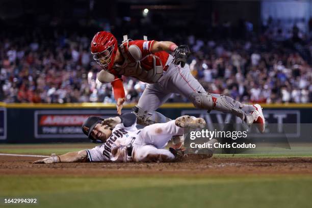 Corbin Carroll of the Arizona Diamondbacks is tagged out trying to reach home plate by Tyler Stephenson of the Cincinnati Reds during the fifth...