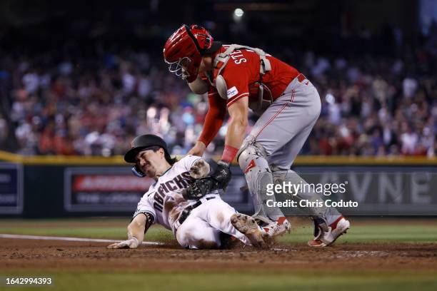 Corbin Carroll of the Arizona Diamondbacks is tagged out trying to reach home plate by Tyler Stephenson of the Cincinnati Reds during the fifth...
