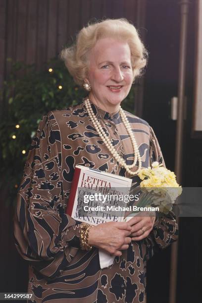 American etiquette expert Letitia Baldrige holding her recent publication 'Complete Guide to Executive Manners', in Baltimore, Maryland, 1985. She is...