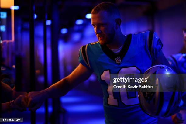 Johnny Hekker of the Carolina Panthers high fives a fan through glass in the tunnel prior to an NFL preseason football game against the Detroit Lions...