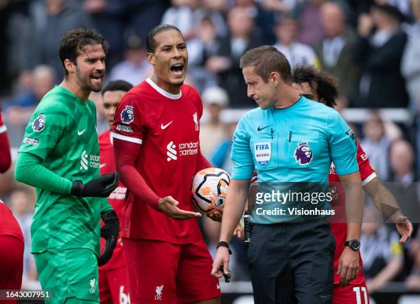 Virgil Van Dijk of Liverpool argues with referee John Brooks after being shown a red card during the Premier League match between Newcastle United...