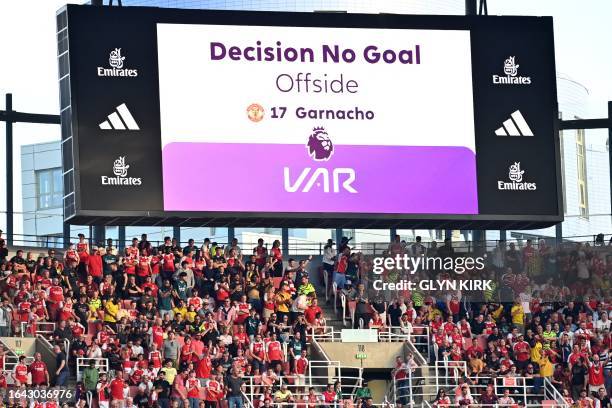 The big screen displays the decision that after a VAR review a goal from Manchester United's Argentinian midfielder Alejandro Garnacho is disallowed...