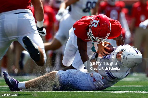 Quarterback Ben Bryant of the Northwestern Wildcats is sacked by defensive back Desmond Igbinosun of the Rutgers Scarlet Knights during the first...