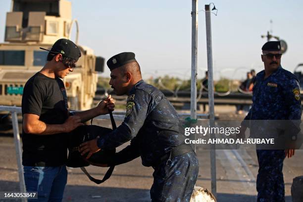 Policeman inspects the bag of a Shiite Muslim pilgrim marching from Baghdad towards the shrine city of Karbala on September 3 ahead of the Arbaeen...