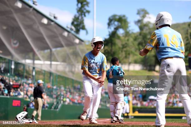 Louis Lappe of the West Region team from El Segundo, California scores a run during the first inning against the Caribbean Region team from...