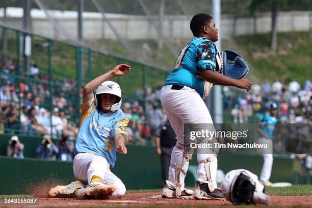 Brody Brooks scores a run during the fourth inning against the Caribbean Region team from Willemstad, Curacao during the Little League World Series...