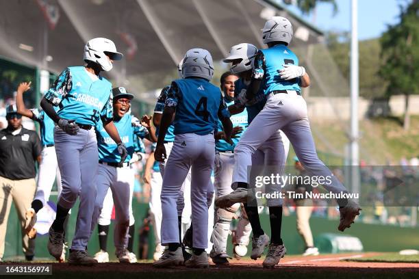 Nasir El-Ossaïs of the Caribbean Region team from Willemstad, Curacao reacts with teammates after hitting a home run during the fifth inning against...