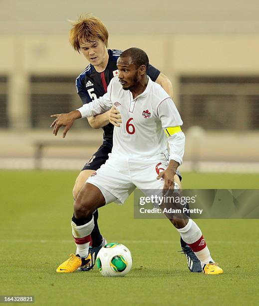 Gotoku Sakai of Japan challenges Julian De Guzman of Canada during the international friendly match between Japan and Canada at Khalifa International...