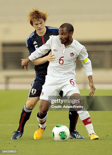 Gotoku Sakai of Japan challenges Julian De Guzman of Canada during the international friendly match between Japan and Canada at Khalifa International...