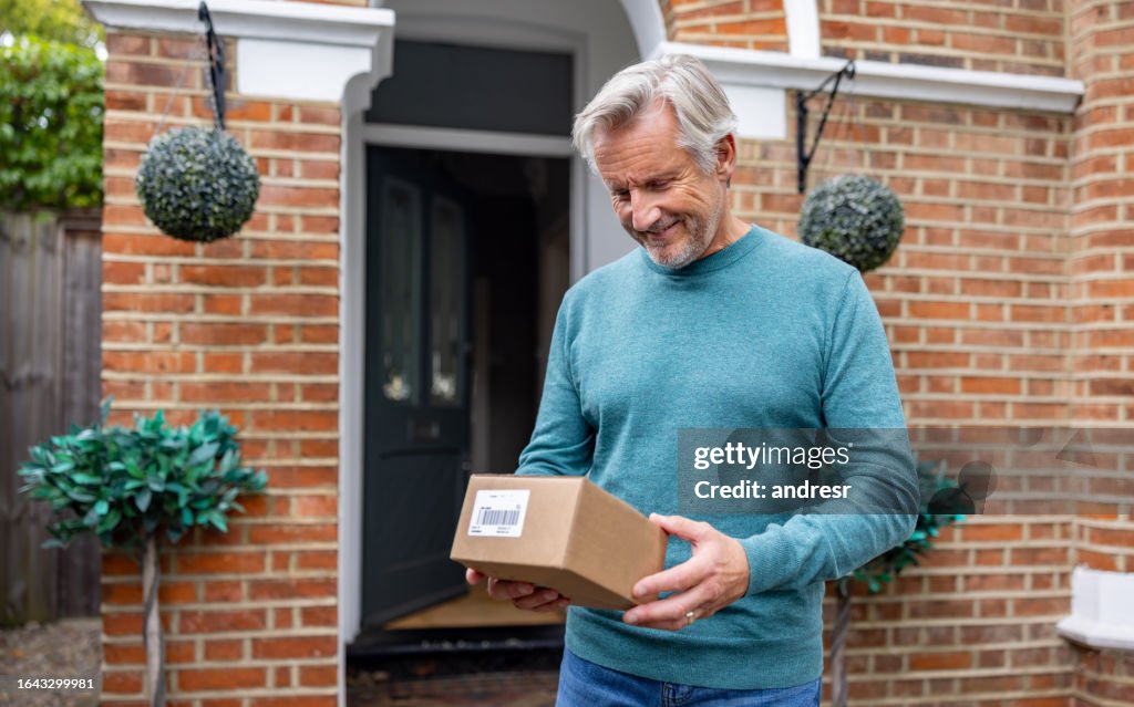 Happy senior man receiving an e-commerce package in the mail