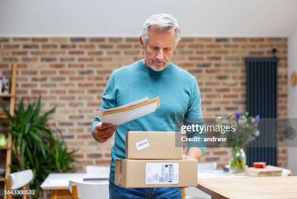 senior man at home receiving packages in the mail - message sent stock pictures, royalty-free photos & images