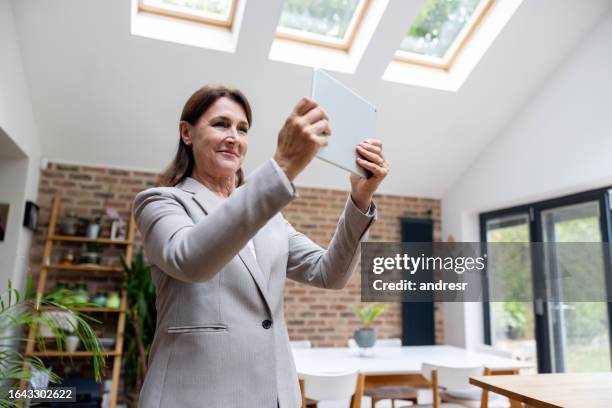 real estate agent taking pictures of a property using a digital tablet - virtual visit stock pictures, royalty-free photos & images