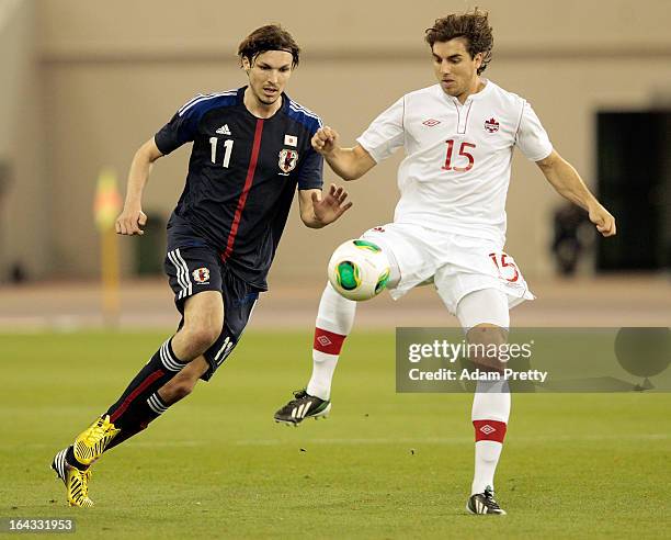 Mike Havenaar of Japan challenges Dejan Jakovic of Canada during the international friendly match between Japan and Canada at Khalifa International...