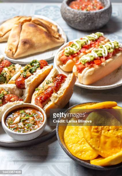 chilean traditional food for independence day - chorinan, empanadas de pino, sopaipollas and completos italianos - completo stock pictures, royalty-free photos & images