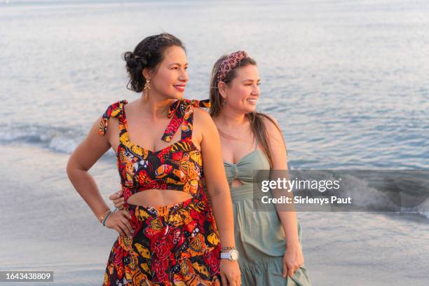seaside laughter between two friends - mid volwassen vrouw stockfoto's en -beelden
