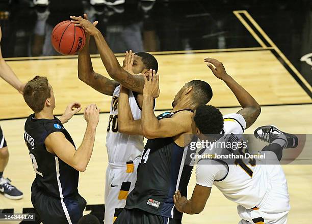 Troy Daniels of the VCU Rams tries to rebound as he is hit by Zeke Marshall of the Akron Zips as Brian Walsh defends and Juvonte Reddic battles...