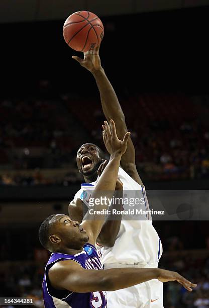 Patric Young of the Florida Gators reaches for the ball over Gary Roberson of the Northwestern State Demons during the second round of the 2013 NCAA...