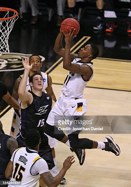 Rob Brandenberg of the VCU Rams shoots over Jake Kretzer of the Akron Zips during the second round of the 2013 NCAA Men's Basketball Tournament at...
