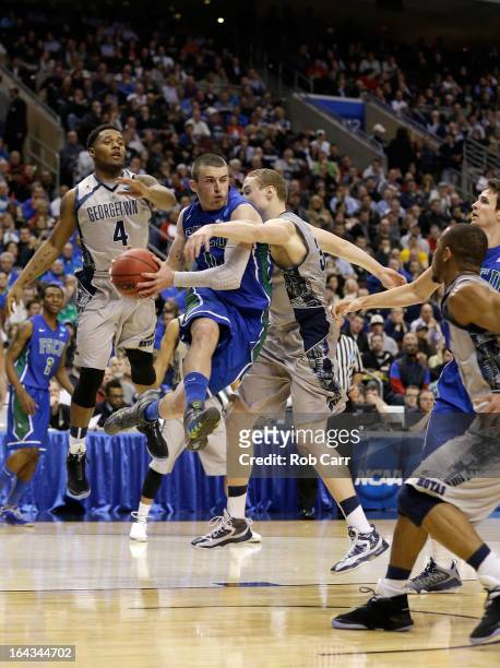 Brett Comer of the Florida Gulf Coast Eagles looks to pass the ball in the second half as he drives against Nate Lubick and D'Vauntes Smith-Rivera of...