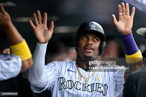 Elehuris Montero of the Colorado Rockies celebrates in the dugout after scoring a run in the fifth inning against the Toronto Blue Jays at Coors...