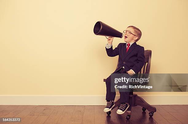 young business boy sitting in chair yelling through megaphone - beckoning stock pictures, royalty-free photos & images