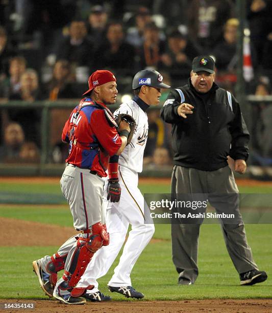 Seiichi Uchikawa of Japan gets caught in a rundown by Yadier Molina of Puerto Rico in the eighth inning of the semifinals of the World Baseball...