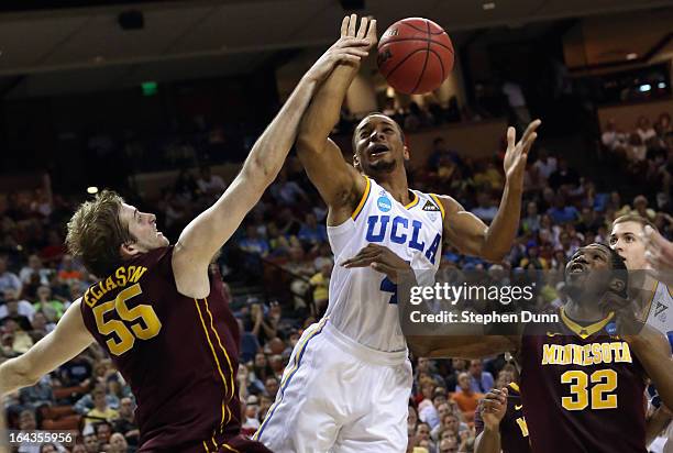 Norman Powell of the UCLA Bruins takes a shot over Elliott Eliason and Trevor Mbakwe of the Minnesota Golden Gophers during the second round of the...