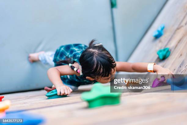 energetic asian baby girl enjoying outdoor rock climbing adventure - extreem weer stock pictures, royalty-free photos & images