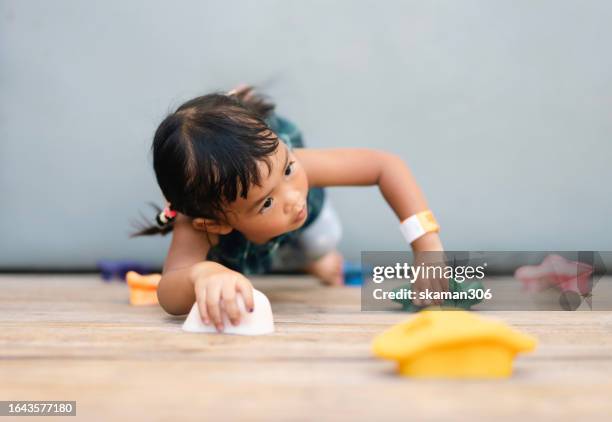 energetic asian baby girl enjoying outdoor rock climbing adventure - extreem weer stock pictures, royalty-free photos & images
