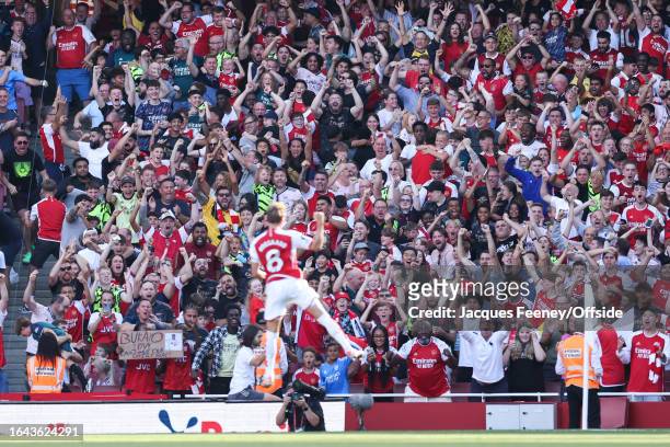 Arsenal fans celebrate their first goal by Martin Odegaard of Arsenal during the Premier League match between Arsenal FC and Manchester United at...