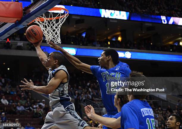 Georgetown Hoyas guard Markel Starks gets fouled from behind by Florida Gulf Coast Eagles forward Eric McKnight as he goes up for two points in the...