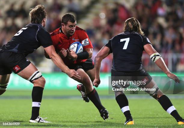 Corey Flynn of the Crusaders runs into the tackle of David Bulbring and Wimpie van der Walt of the Kings during the round six Super Rugby match...