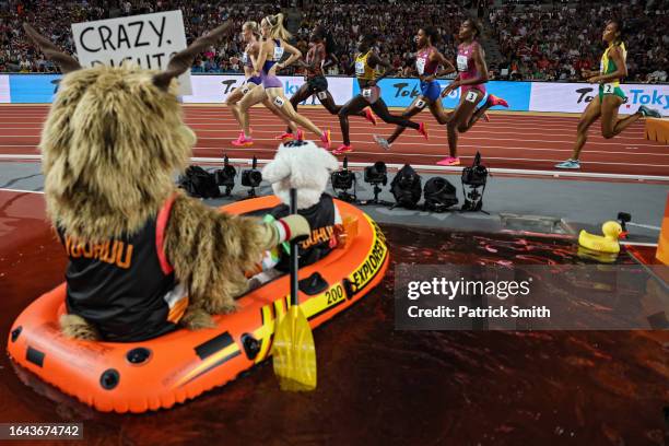 Runners compete in the Women's 800m Final as mascot Youhuu sits in a boat in the steeplechase water obstacle during day nine of the World Athletics...