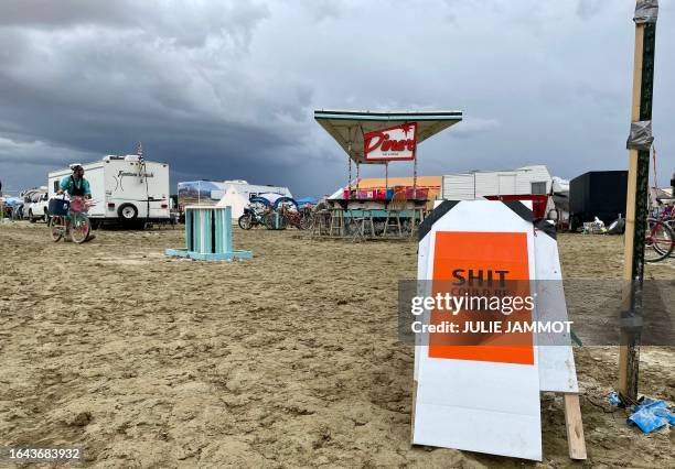 Sign reading "Shit Could Be Worse" as campers sit in a muddy desert plain on September 3 after heavy rains turned the annual Burning Man festival...