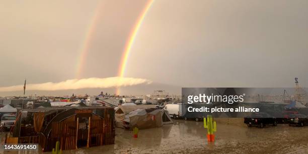 September 2023, USA, Black Rock: Undated image shows rainbow seen over the muddy grounds of the "Burning Man" festival. Tens of thousands of visitors...
