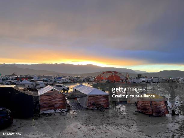 September 2023, USA, Black Rock: The undated photo shows tents between puddles and mud on the grounds of the "Burning Man" festival. Tens of...