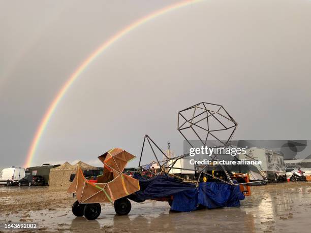 September 2023, USA, Black Rock: The undated image shows a rainbow seen over the muddy grounds of the "Burning Man" festival. Tens of thousands of...