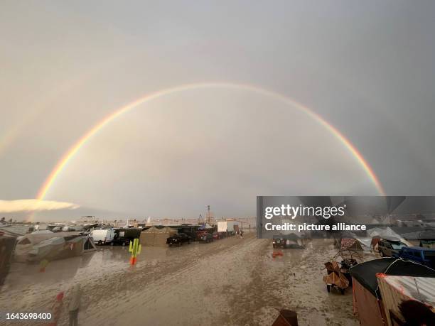 September 2023, USA, Black Rock: The undated image shows a rainbow seen over the muddy grounds of the "Burning Man" festival. Tens of thousands of...