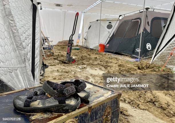 Pair of Teva sandals are seen on a chest in the middle of tents sitting in a muddy desert plain on September 3 after heavy rains turned the annual...