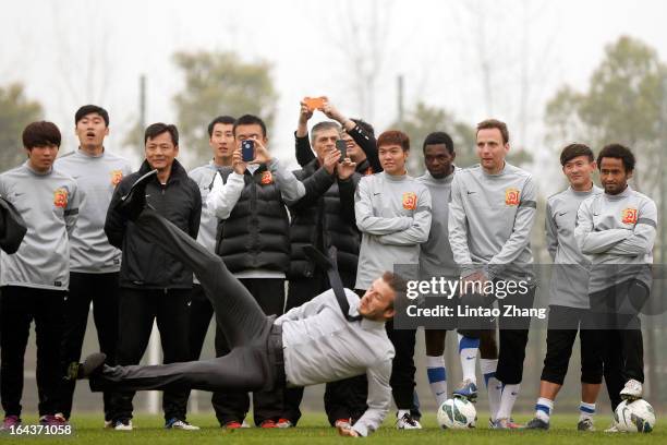 British football player David Beckham slips after kicking the ball during a visit to Wuhan Zall Football Club on March 23, 2013 in Wuhan, China....