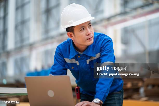 factory engineer using laptop while inspecting machine operation inside paper mill - electrical distribution stock pictures, royalty-free photos & images