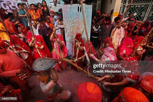 Indian women beat men with wooden sticks during the Lathmar Holi festival at the Nandji Temple in Nandgaon, some 120 kms far from New Delhi, on March...