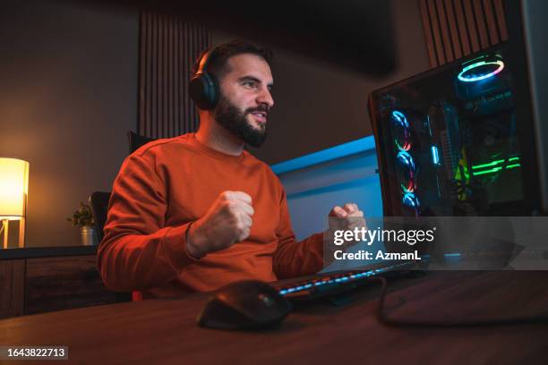 victorious man reacting with his hands when winning the game - computer cpu stock pictures, royalty-free photos & images